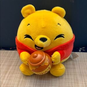 ZURU Snackles Disney Winnie the Pooh plush toy holding a honey pot
